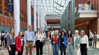 Photo of a group of Michigan Ross students who are part of the Center for Positive Organizations standing inside the Michigan Ross Winter Garden.
